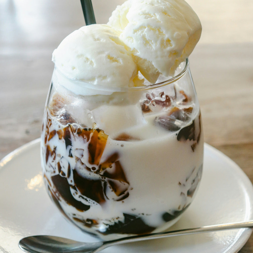 Vanilla ice cream with hot steeped tea poured over, served in a clear glass