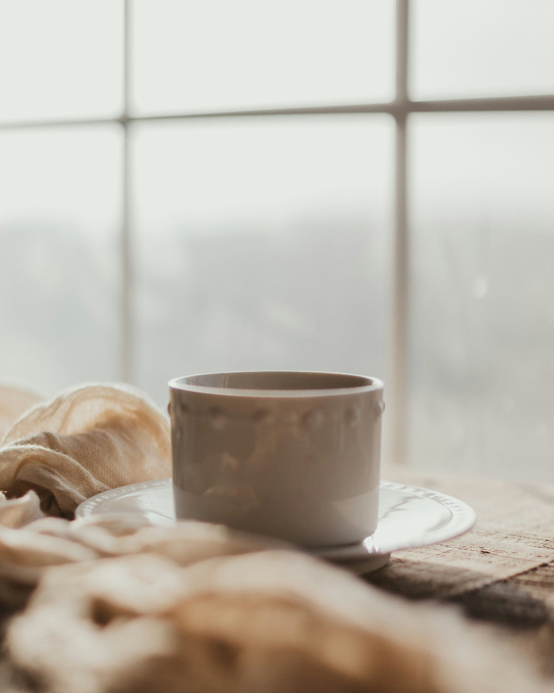 Ceramic tea mug on a windowsill with a soft focus background
