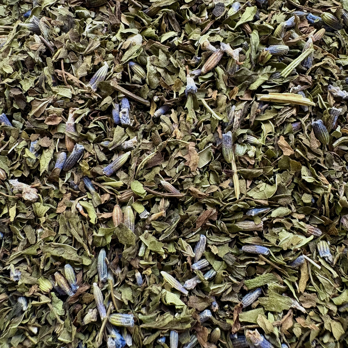 Loose-leaf Moonlit Mint tea blend showing a vibrant mix of dried green mint leaves and delicate purple lavender blossoms.