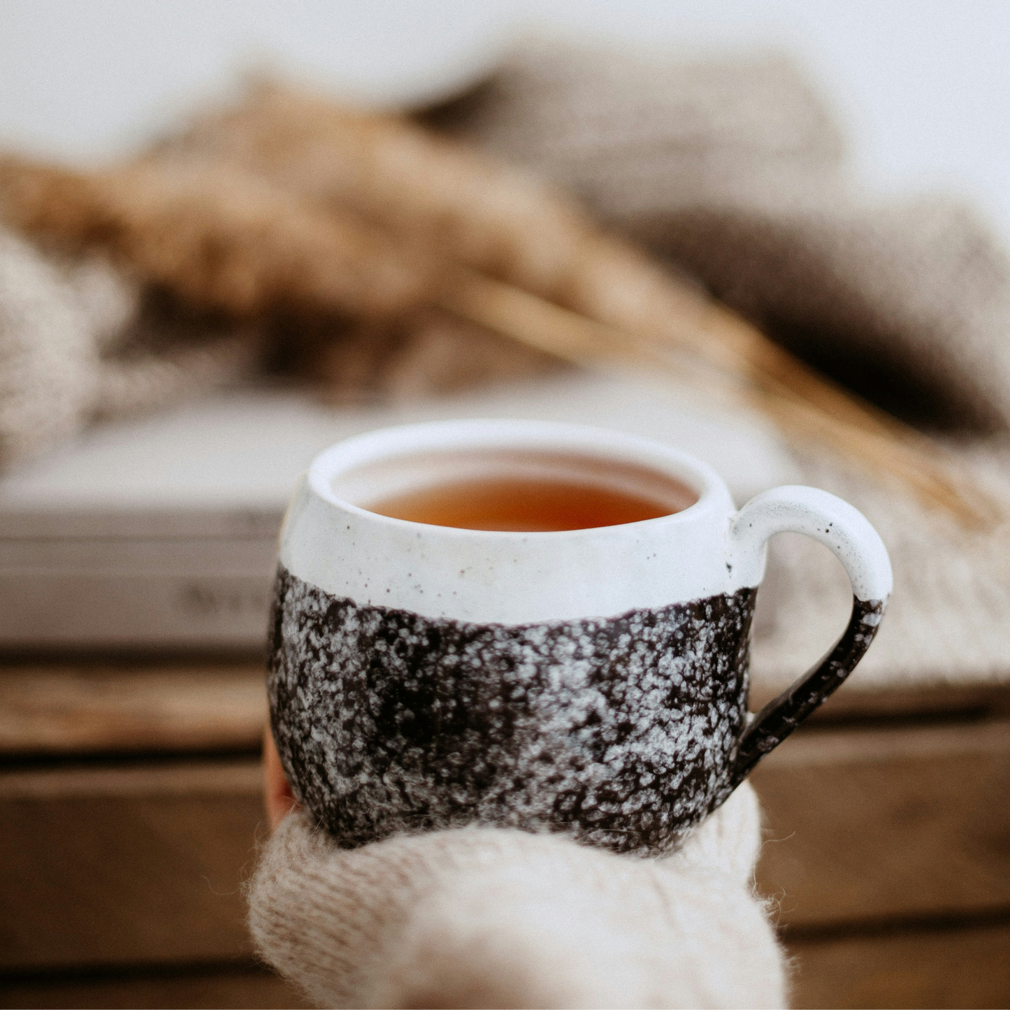 Mug with a warm beverage on a wooden surface with a blurred background