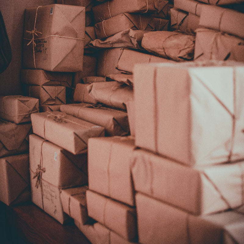 Stacks of brown paper packages in a dimly lit room